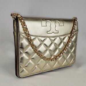 Shimming gold clutch Gold toned hardware featuring a chain strap interwoven with leather Tory Burch "T" accent  100% embossed calfskin leather Light tan fabric interior Snap closure with top flap 2 interior compartments separated by slim, slip compartment  Adjustable, detachable shoulder strap 10.5” x 8” x 1.5” Chain drop: 7" Shoulder strap drop: 21.5 - 24.5" Product number 192485331639 Made in China