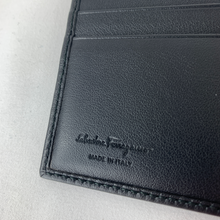 Load image into Gallery viewer, A classic black leather wallet is a staple piece that every man should have. Polished and sophisticated, a simple yet opulent bi-fold wallet will keep all your essentials organized in a compact design that can slip into your pocket. With 6 card slots, 1 full length bill slot, and 2 half sized slip pockets, this slim wallet can fit everything you need with ease. Grab this Ferragamo classic and go about your day with style and superior organization!