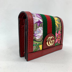 The top flap with snap closure opens to a zipped coin pouch, 1 bill slot, and 5 card slots. Coming in a forest green dust bag and holographic palm tree box, this wallet can be used and stored in style!