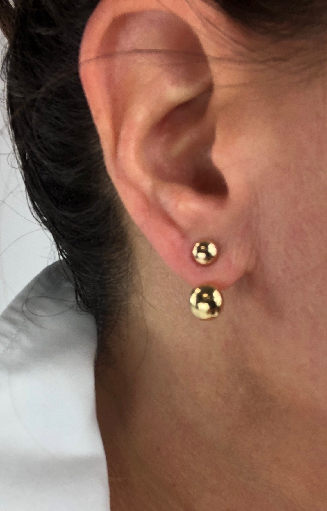 100% 14K Yellow Gold ball earrings with adjustable ear jacket. Create a double layered look with adjustable ear jacket to fit any size ear lobe. Dual polished gold balls hang elegantly as a stud and just under your ear, connected in the back for an invisible drop