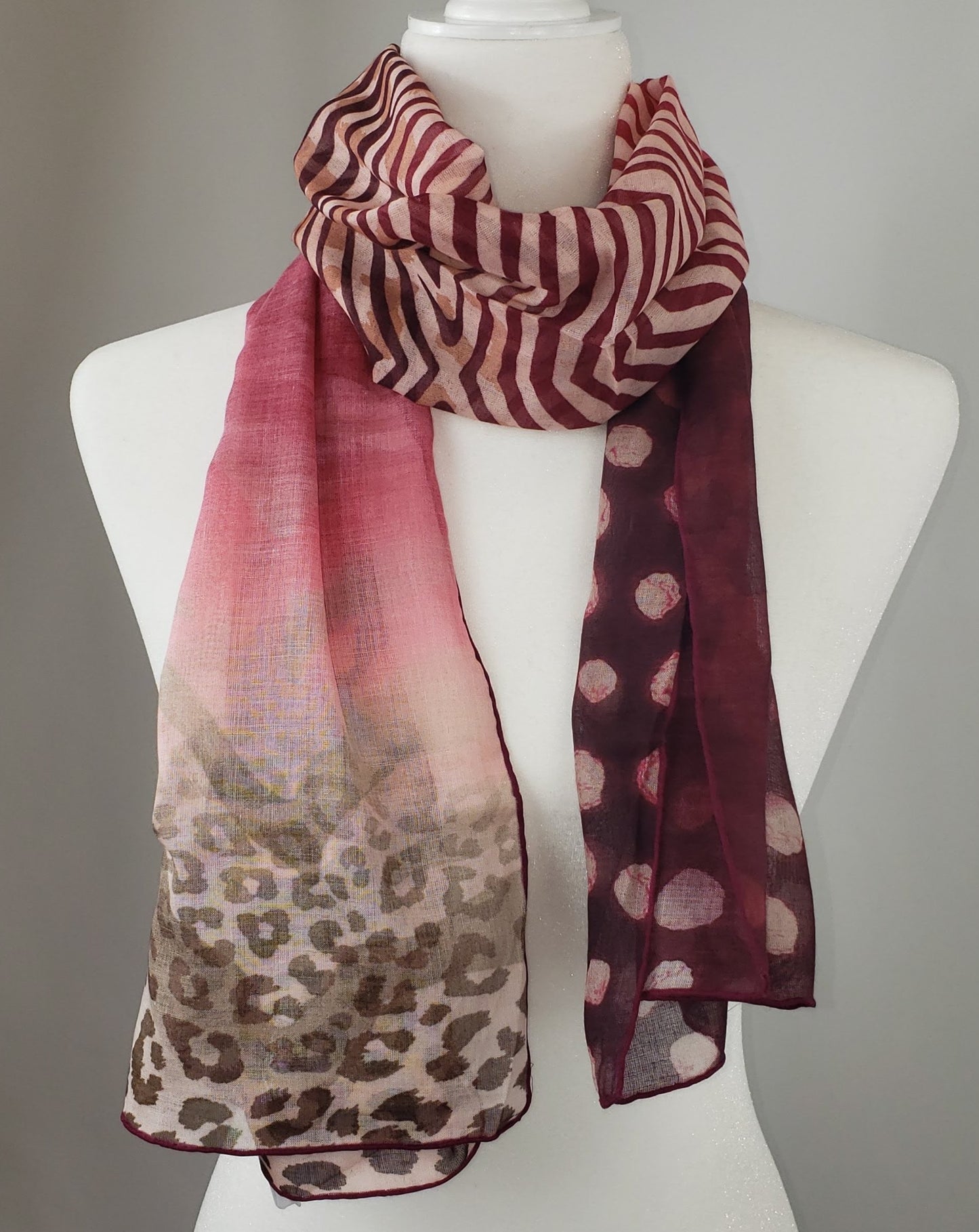 We are obsessed with this soft and luxurious scarf from Salvatore Ferragamo. A perfect blend of red and burgundy hues, this scarf is bold and bright, while maintaining a distinguished and fashionable feel. Tiger, zebra, and leopard prints are intricately placed in a gorgeous pattern that needs to be shown off! Red, burgundy, and coral in an animal print 92% Modal, 8% Cashmere 60" x 17" (152.4cm x 43.18cm) Comes in Ferragamo scarf box Made in Italy