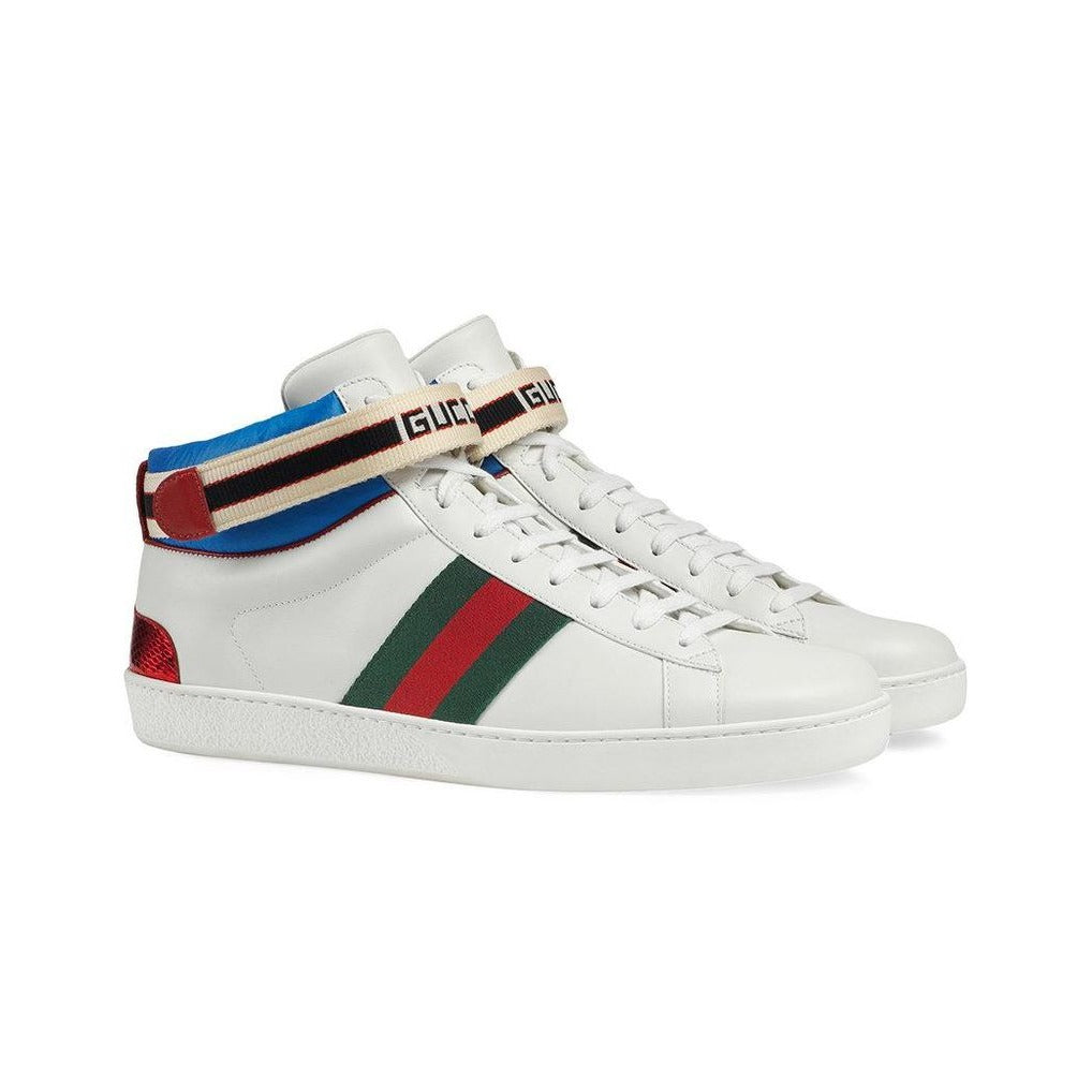The Gucci Stripe Ace High-top Sneakers is a sporty, 80's inspired shoe with a modern take to be worn everyday. Made in white leather with a signature Gucci web, this shoe has blue nylon trim and a red and black Gucci Jacquard stripe velcro strap. The back of these high tops features a red ayers snake detail, the perfect finishing touch on this pair. 