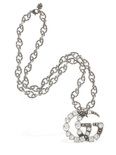 Load image into Gallery viewer, The Gucci GG Marmont Crystal Necklace In Silver is a rare and unique piece by none other than Gucci. A crystal encrusted GG pendant hangs from a delicate, intricately carved chain. A feline head charm hangs from the clasp. 