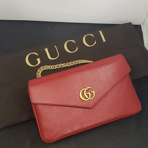 Red and black envelope bag Gold-toned hardware Classic GG emblem on red side Crystal tiger clasp laid on gold striped design on black side 100% Leather 10.5 x 6.25" x 2" Chain drop 5" Strap drop 20-24" Comes in Gucci dust bag Product number 808303758 Made Italy