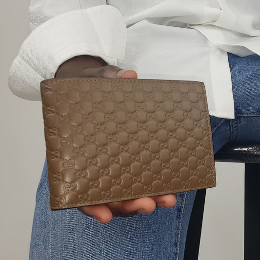 Gucci camel color leather bifold men’s wallet. Perfect size for your everyday needs. It boasts the beautiful GG embossed finish for a timeless style that you'll love year after year. With six credit card slots, one coin pocket, and one bill compartment, all of your cards, cash, and coins can be easily accessed and stored. Make this Gucci piece your go-to wallet!