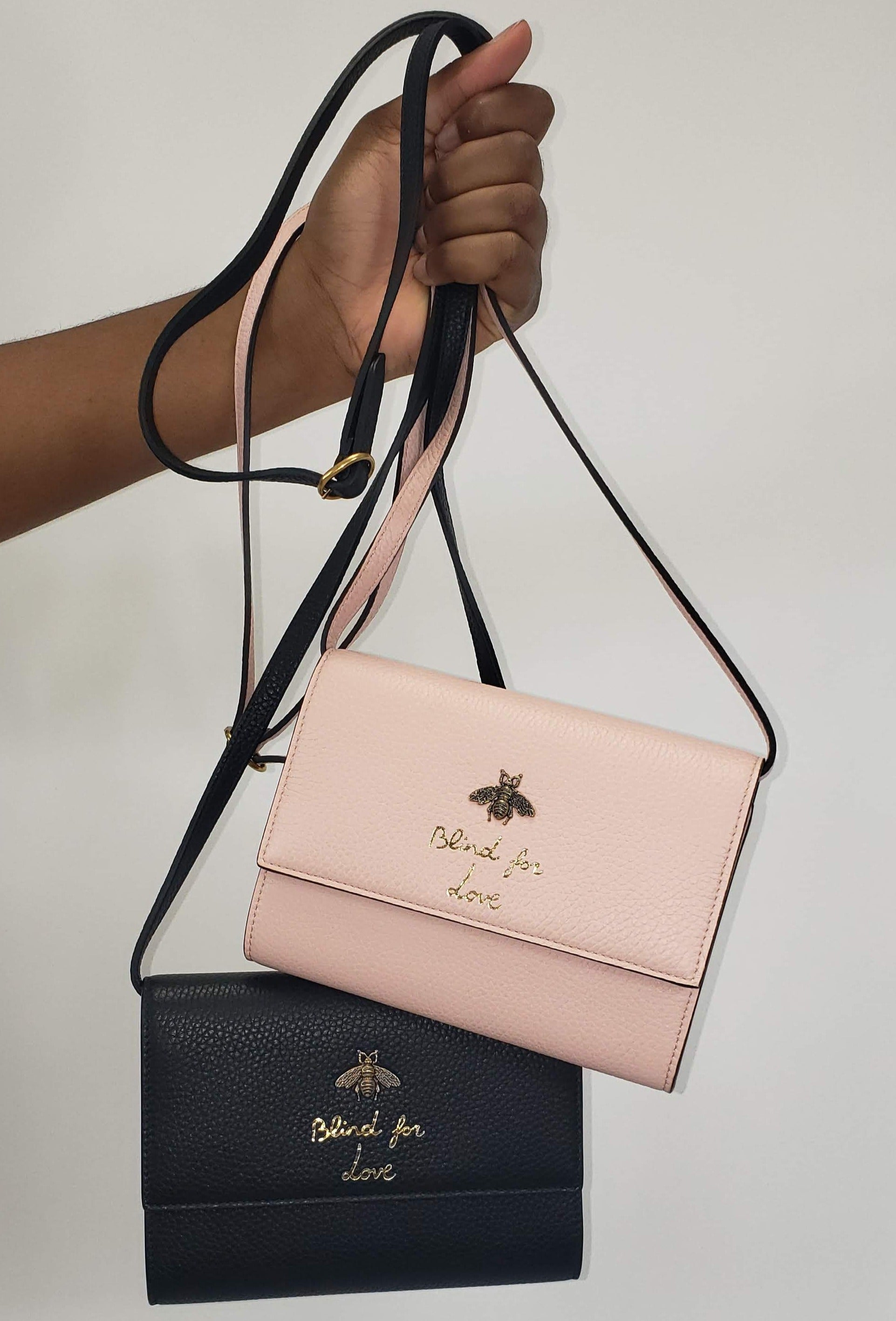 Made in Perfect Pink with an adorable gold bee accent and "blind for love" lettering, this small purse is a great addition to your look! Supple leather comes together with a snap closure for a simplistic, elegant design. The interior is spacious enough to hold your beloved devices, and also has 4 card slots to keep you organized. Use as a crossbody bag or remove the strap and use it as a clutch.