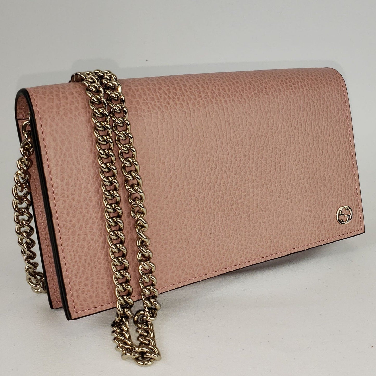 This chic wallet on chain is crafted of textured calfskin leather. The shoulder bag features a shoulder chain and a small Gucci GG emblem. It opens to a matte leather interior with a spacious zippered currency compartment, and card slot panels. This is an ideal chain wallet for keeping contents close at hand, by Gucci! The chain is removable so you can carry this bag as a wallet or wear is as a cross body.