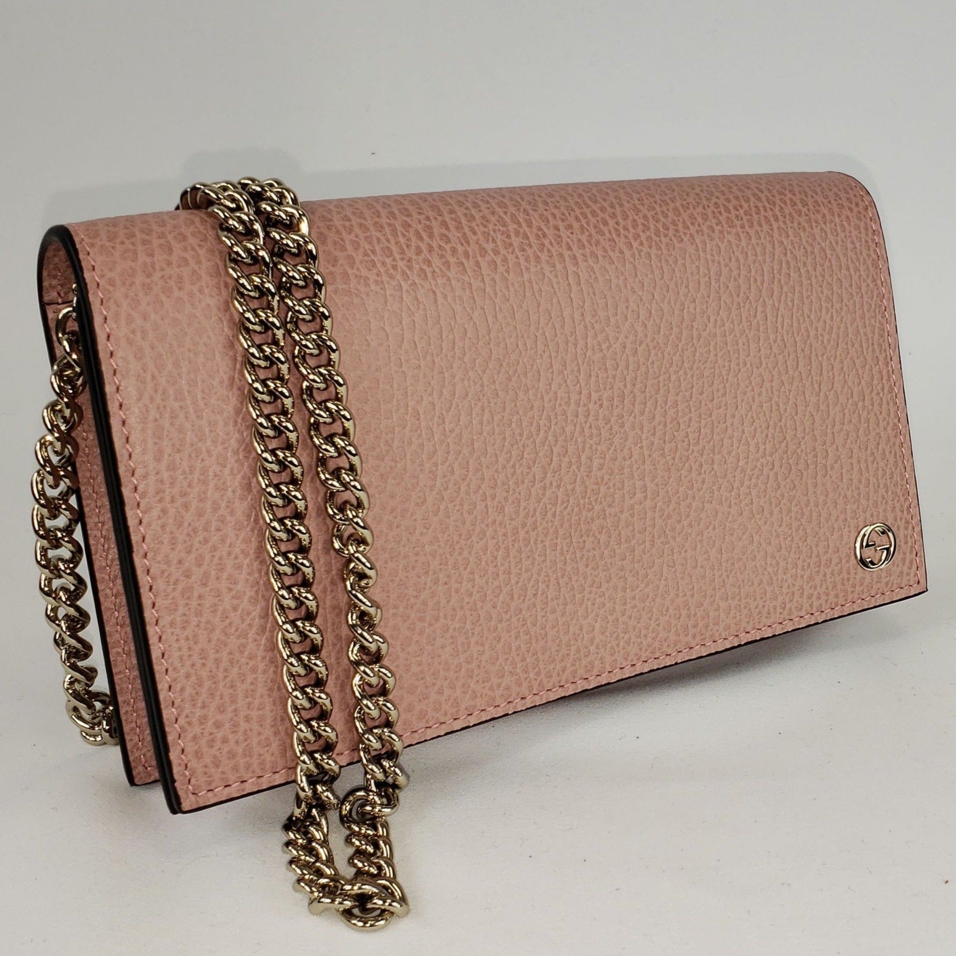 This chic wallet on chain is crafted of textured calfskin leather. The shoulder bag features a shoulder chain and a small Gucci GG emblem. It opens to a matte leather interior with a spacious zippered currency compartment, and card slot panels. This is an ideal chain wallet for keeping contents close at hand, by Gucci! The chain is removable so you can carry this bag as a wallet or wear is as a cross body.