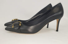 Load image into Gallery viewer, Black pumps are a must have in any closet, and these Ferragamo Black Airola pumps are one of our favorites! In a chic black leather with an elegant silhouette, this pointed toe feel is perfect for business professional looks or nighttime fits. Featuring a leather buckle and gold signature Gancini accent, this is a sophisticated showstopper. Paired with jeans or a little black dress, this shoe is sure to complete your look!