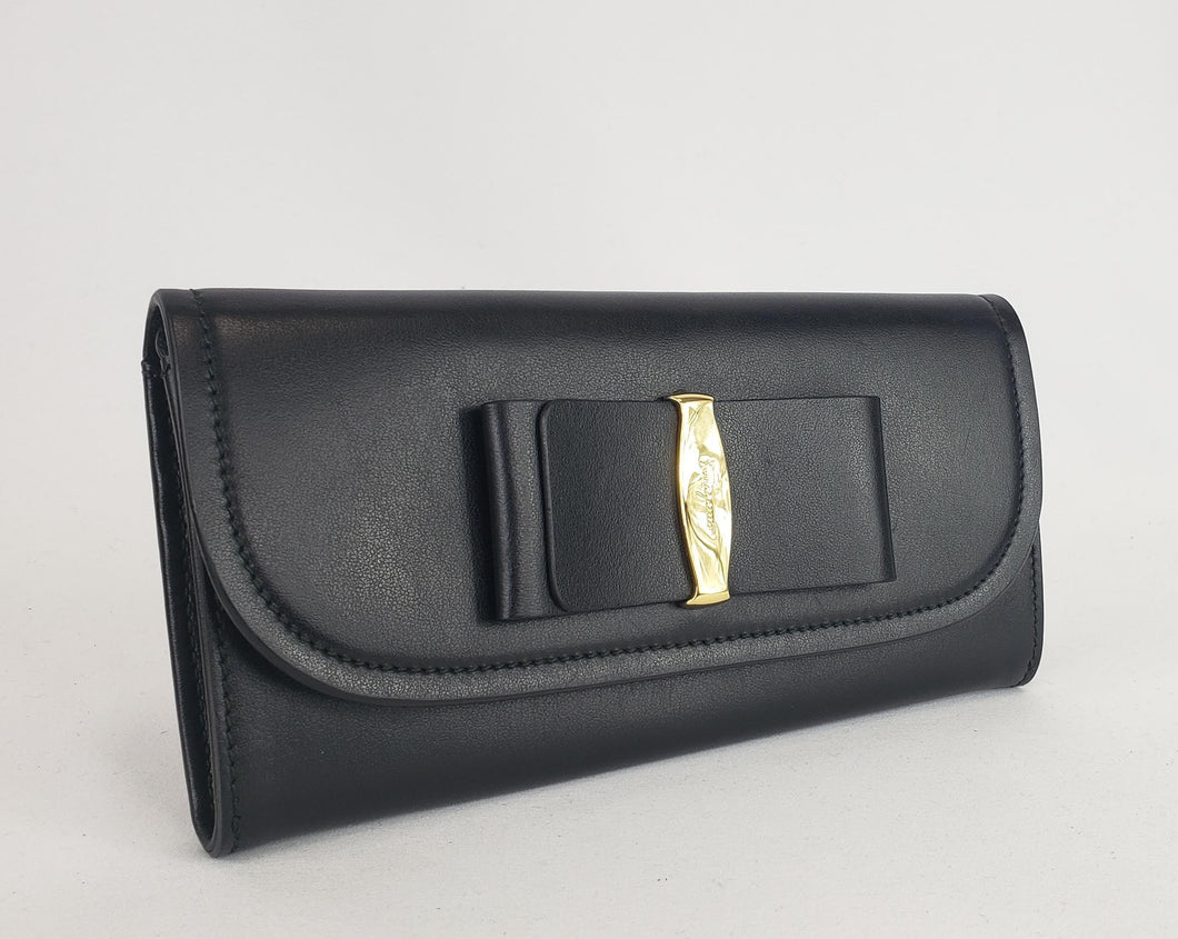 With a wallet as adorable as this, you'll love pulling it out to revel in its design! A sleek black leather is constructed into a long flap wallet with a chic, classic vara bow on the front. In a timeless black with gold accents to add a touch of shine, this wallet will match with everything and will be perfect to tuck into your favorite handbag. 