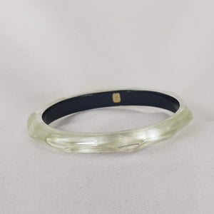 This signature faceted Lucite bangle in clear ivory is sure to impress. This bracelet can be stacked or worn alone. The bracelet is hand sculpted in the United States.  The "Alexis Bittar" tag in on the inside of the bracelet. The piece will fit most wrist sizes with a circumference of 7.5". 