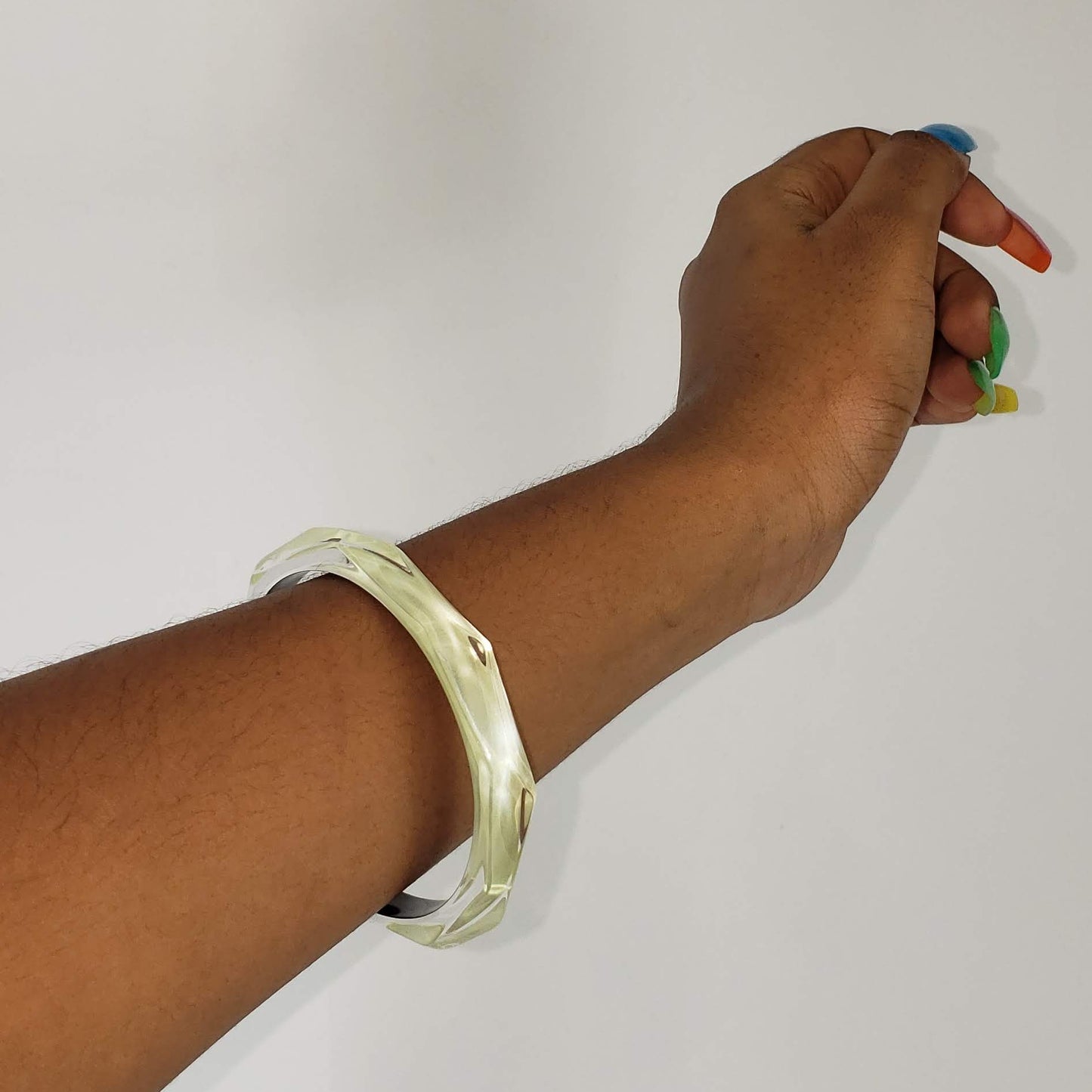 This signature faceted Lucite bangle in clear ivory is sure to impress. This bracelet can be stacked or worn alone. The bracelet is hand sculpted in the United States.  The "Alexis Bittar" tag in on the inside of the bracelet. The piece will fit most wrist sizes with a circumference of 7.5". 