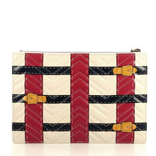 Load image into Gallery viewer, The Gucci Matelasse Trompe L&#39;Oeil Print GG Marmont Pouch in White is crafted of lovely textured calfskin leather in black. This bag features chevron stitching, an aged gold interlocking GG logo and a beige fabric interior. The pattern is designed into woven navy and red stripes with print buckles. The term &quot;trompe l&#39;oeil&quot; is French for a visual illusion in art, especially as used to trick the eye into perceiving a painted detail as a three-dimensional object. 