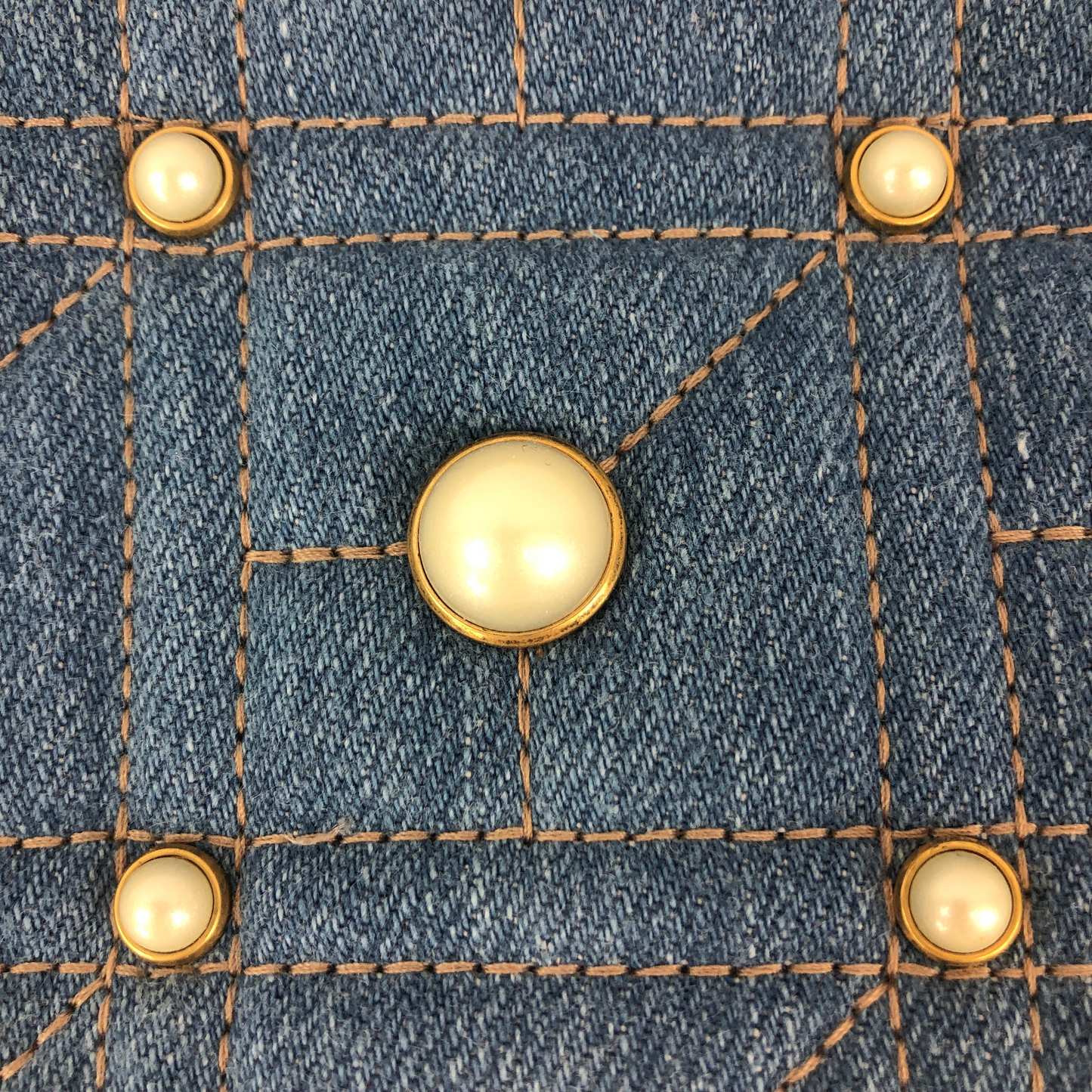 The Gucci Marmont Pearl Crossbody Bag in Denim is a modern take on a classic look. Light wash Matelassé denim Gucci Small GG Marmont Pearl Shoulder Bag with gold-tone hardware, single flat shoulder strap with chain-link accents, creme contrast stitching throughout, Running GG adornment at front face, pearl embellishments throughout exterior, coral satin interior lining, single interior slit pocket and zip closure at top. Includes dust bag. Authentic and rare handbags from Gavriel.us