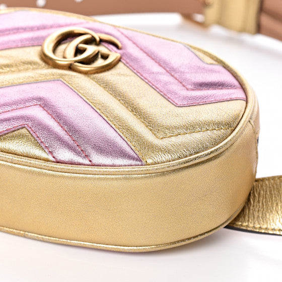 This belt bag is crafted of smooth gold and pink chevron stitched leather. This bag is an oval shape with a leather belt that can be worn as a belt bag. The belt bag features an aged gold GG logo on the front and a heart stitched shape on the back of the bag with an adjustable belt closure. The handbag opens to a blue satin interior with a patch pocket. This compact, yet spacious belt bag is perfect for any time of the day; whether it be for casual or formal wear, from Gucci!