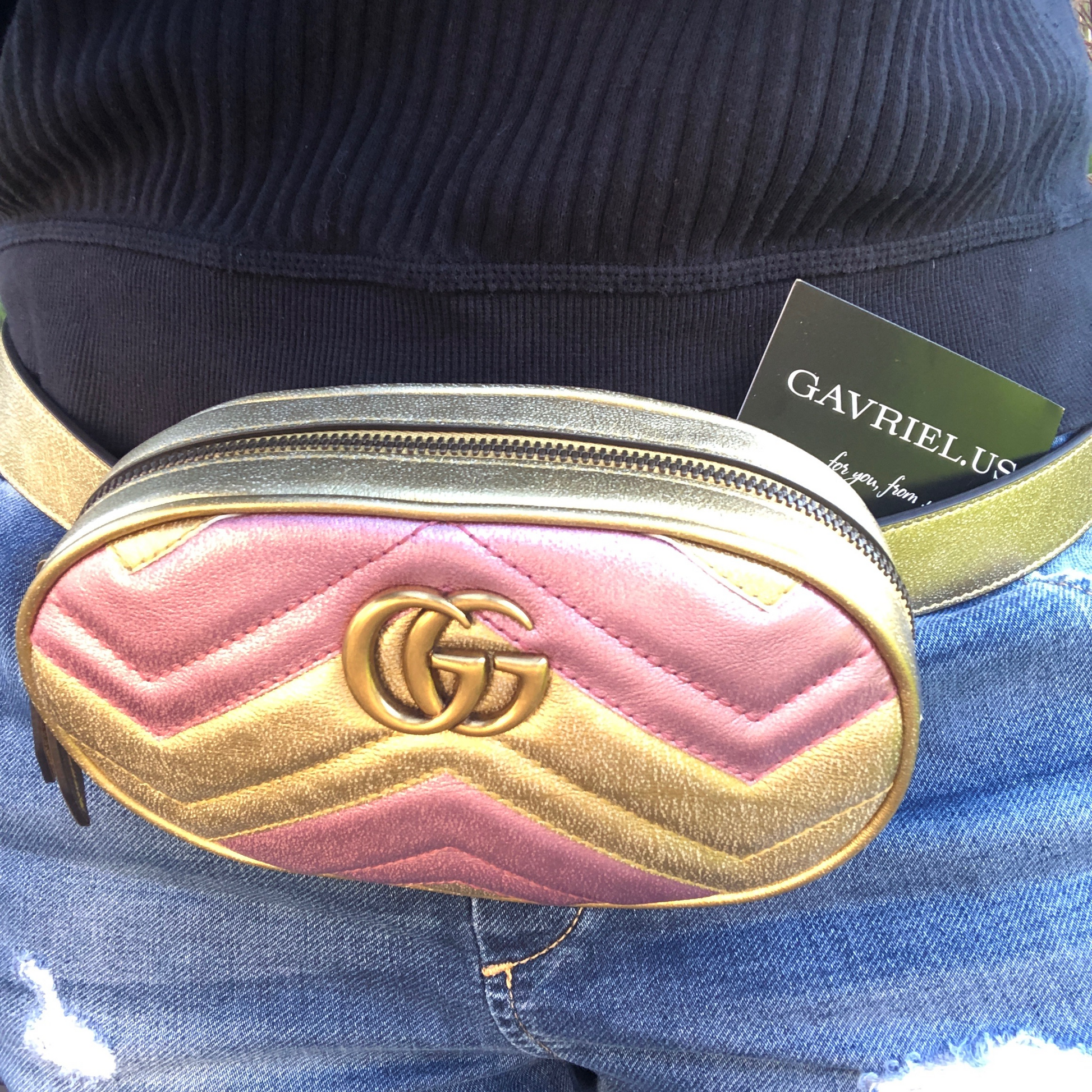 This belt bag is crafted of smooth gold and pink chevron stitched leather. This bag is an oval shape with a leather belt that can be worn as a belt bag. The belt bag features an aged gold GG logo on the front and a heart stitched shape on the back of the bag with an adjustable belt closure. The handbag opens to a blue satin interior with a patch pocket. This compact, yet spacious belt bag is perfect for any time of the day; whether it be for casual or formal wear, from Gucci!