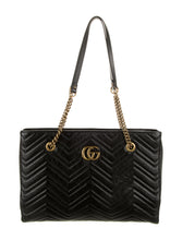 Load image into Gallery viewer, The Gucci GG Marmont Matelassé Leather Shoulder Bag in Black is a gorgeous leather bag with a tote silhouette which is accented by antique gold-tone hardware. Exquisite matelasse stitching accentuates the streamlined silhouette of a trim tote bag branded with antiqued double-G hardware inspired by an archival design.