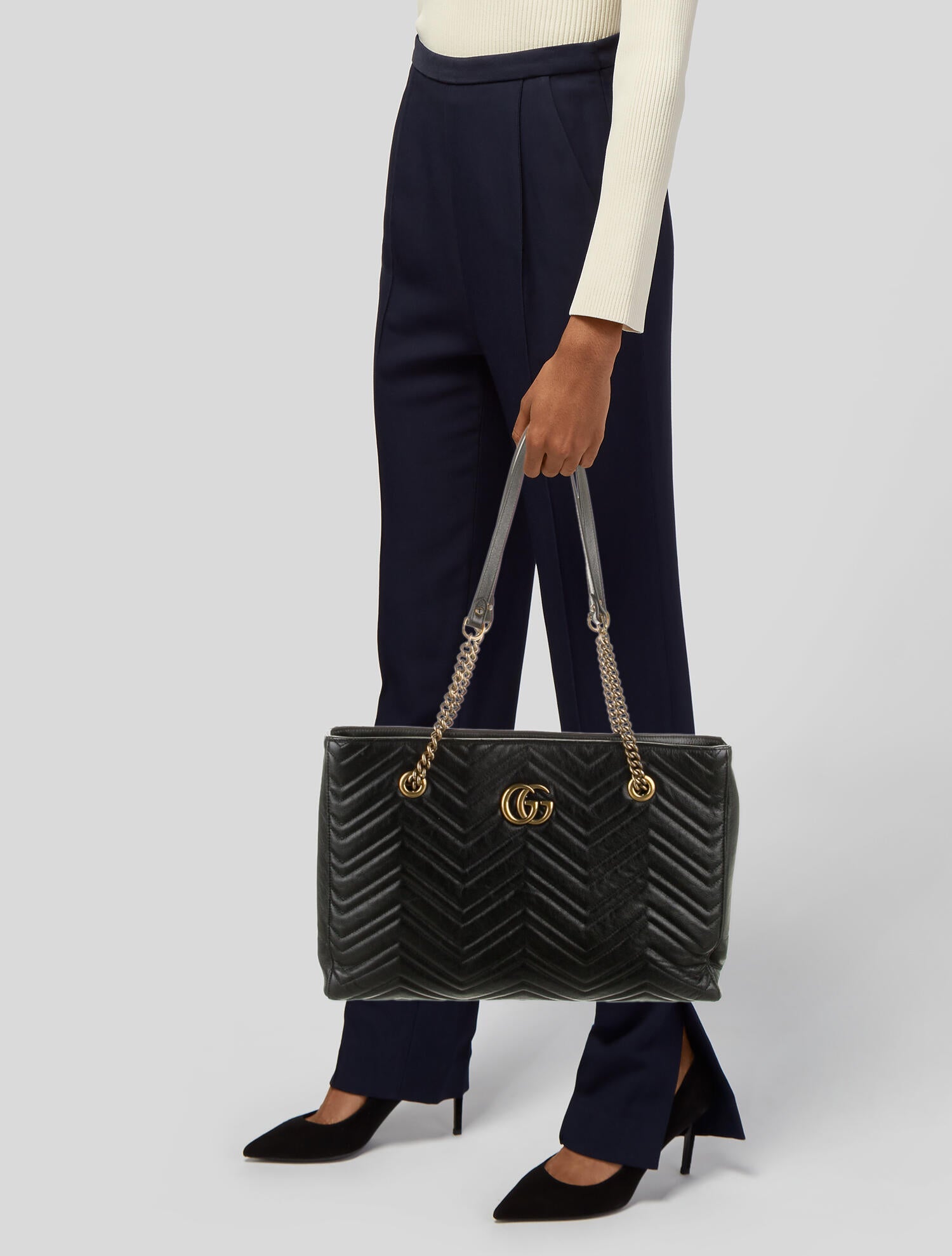 The Gucci GG Marmont Matelassé Leather Shoulder Bag in Black is a gorgeous leather bag with a tote silhouette which is accented by antique gold-tone hardware. Exquisite matelasse stitching accentuates the streamlined silhouette of a trim tote bag branded with antiqued double-G hardware inspired by an archival design.