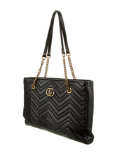 Load image into Gallery viewer, The Gucci GG Marmont Matelassé Leather Shoulder Bag in Black is a gorgeous leather bag with a tote silhouette which is accented by antique gold-tone hardware. Exquisite matelasse stitching accentuates the streamlined silhouette of a trim tote bag branded with antiqued double-G hardware inspired by an archival design.