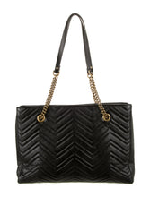 Load image into Gallery viewer, The Gucci GG Marmont Matelassé Leather Shoulder Bag in Black is a gorgeous leather bag with a tote silhouette which is accented by antique gold-tone hardware. Exquisite matelasse stitching accentuates the streamlined silhouette of a trim tote bag branded with antiqued double-G hardware inspired by an archival design.