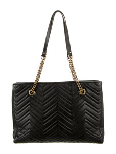 The Gucci GG Marmont Matelassé Leather Shoulder Bag in Black is a gorgeous leather bag with a tote silhouette which is accented by antique gold-tone hardware. Exquisite matelasse stitching accentuates the streamlined silhouette of a trim tote bag branded with antiqued double-G hardware inspired by an archival design.