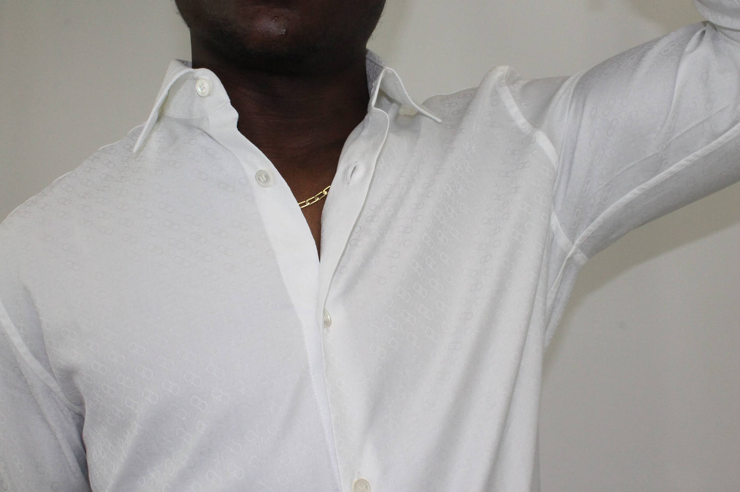 White button down shirt  100% cotton Textured, signature Gancini print  Spread, pointed collar Long sleeves with button cuffs Shirttail hem About 29” from shoulder to hem Machine wash Product number 142980 Made in Italy