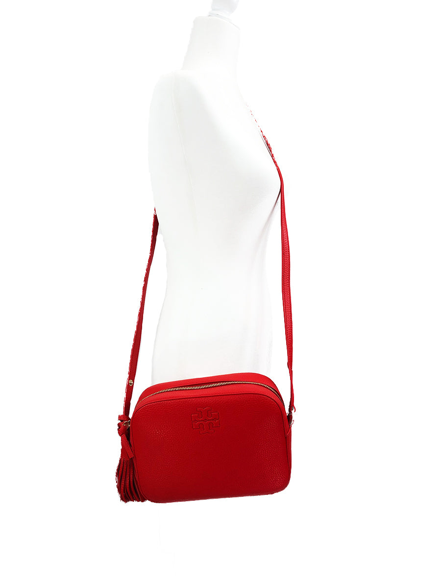 Tory Burch Tonal logo embossing adds understated brand recognition to this compact shoulder bag fashioned from supple pebbled leather, while piped edging and swingy tassels add a bit of extra panache. Top zip closure Optional shoulder strap Interior zip, wall and smartphone pockets Logo-jacquard lining Leather SIZE INFO  9"W x 7"H x 3"D 11 ½" – 23 ¼" convertible strap drop