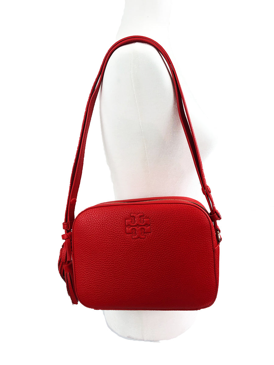 Tory Burch Tonal logo embossing adds understated brand recognition to this compact shoulder bag fashioned from supple pebbled leather, while piped edging and swingy tassels add a bit of extra panache. Top zip closure Optional shoulder strap Interior zip, wall and smartphone pockets Logo-jacquard lining Leather SIZE INFO  9"W x 7"H x 3"D 11 ½" – 23 ¼" convertible strap drop