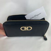 Load image into Gallery viewer, Black wallet Signature gold-toned hardware featuring Ferragamo logo 100% calf skin leather Zip around closure 3 main compartments, 2 bill slots, 8 card holders, and a zipped pouch 7.5&quot; x 4.25&quot; x 1&quot; (19cm x 10.75cm x 2.5cm) Product number 61421 Made in Italy