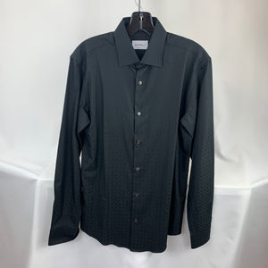 A black Button down shirt is a staple in every man's closet, so why not treat yourself to a little luxury? This Ferragamo shirt is a classic black in a smooth cotton material with the signature GG pattern. This shirt has sharp pointed color and cuffs secured with a simple button, making it a must have in your closet. Whether you wear it tucked into a pair of dress pants, under a sport coat, or with a nice pair of jeans, this shirt is versatile and will leave you looking your best at all times!