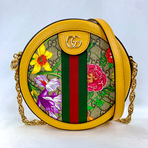 Brighten up your wardrobe with the Gucci mini Ophidia GG Flora round crossbody in a sunny yellow. A slim, rounded silhouette is crafted from GG supreme canvas and pebbled leather to create this fun and unique bag. This accessory is covered in a multicolor flora print that is accented by mustard yellow trim and a signature red and green web. 