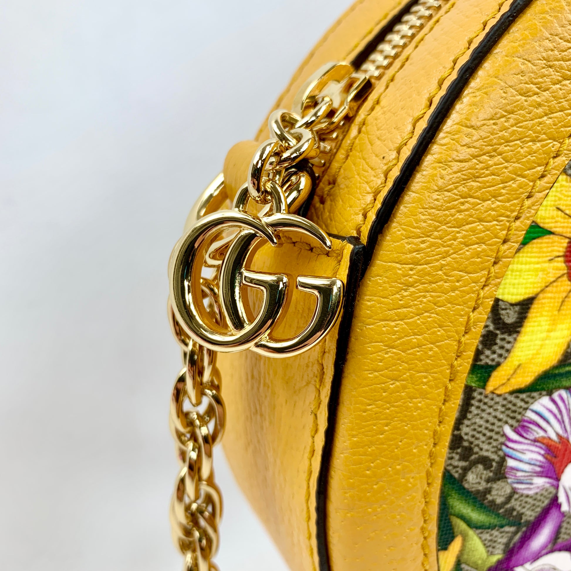 Yellow Ophidia GG Flora round crossbody bag Flora patterned body Beige interior lining  Gold-toned hardware  GG Supreme canvas Leather trim, accents, and strap Signature Gucci web GG logo accent at top and small charm 7.5" x 7.5" x 1.75" Strap drop 22.75" Product number 550618 Made in Italy 