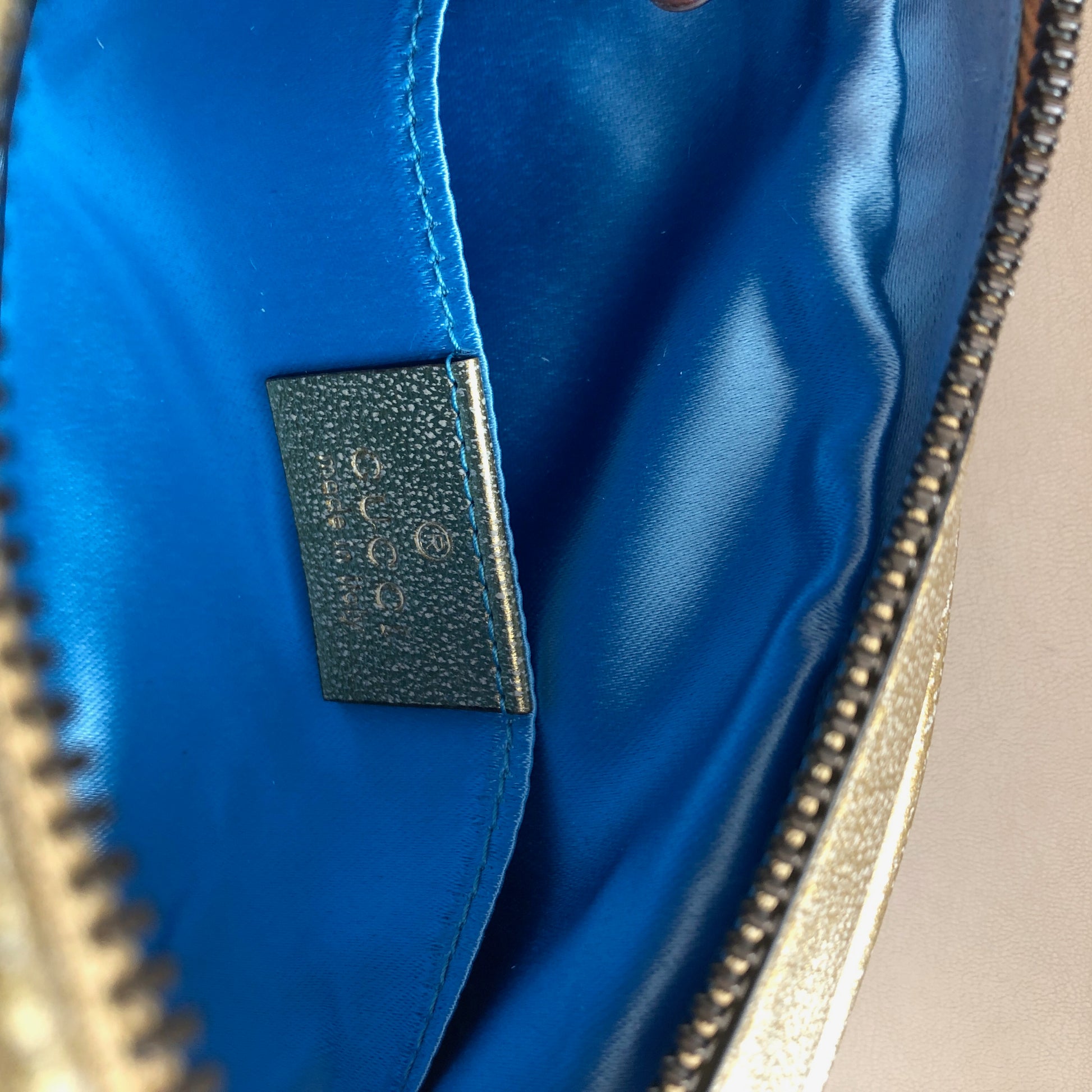 This belt bag is crafted of smooth gold and pink chevron stitched leather. This bag is an oval shape with a leather belt that can be worn as a belt bag. The belt bag features an aged gold GG logo on the front and a heart stitched shape on the back of the bag with an adjustable belt closure. The handbag opens to a blue satin interior with a patch pocket. This compact, yet spacious belt bag is perfect for any time of the day; whether it be for casual or formal wear, from Gucci!