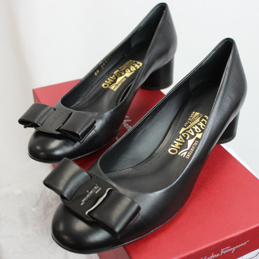 Black pumps. The go to shoe when you're in a pinch! Salvatore Ferragamo takes the traditional black heel to a new level with a luxurious spin. Made of supple, genuine calf leather, these shoes will mold to your feet and keep you comfortable through your whole event. In signature Ferragamo fashion, a vara bow is delicately laid on the front of each round-heeled pump as an adorable and sophisticated accent. This stacked heel pump is the perfect shoe to rock your next look!