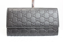 Load image into Gallery viewer, This iconic wallet is made in a black leather with the signature interlocking double G pattern. A Gucci classic, this snap wallet is the perfect size to hold as a clutch or stick in your favorite handbag. With 2 interior compartment, 2 bill slots, 12 card holders, and a zipped pouch, you can fit everything you need in a luxurious little wallet! You&#39;ll fall in love as soon as this gorgeous piece is in your sight!