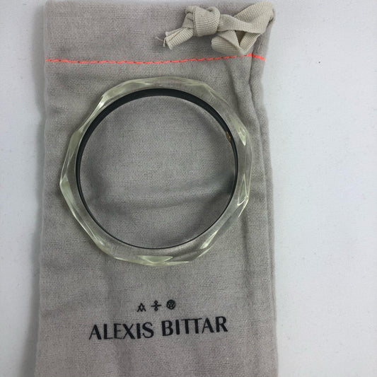 This signature faceted Lucite bangle in clear ivory is sure to impress. This bracelet can be stacked or worn alone. The bracelet is hand sculpted in the United States.  The "Alexis Bittar" tag in on the inside of the bracelet. The piece will fit most wrist sizes with a circumference of 7.5". 