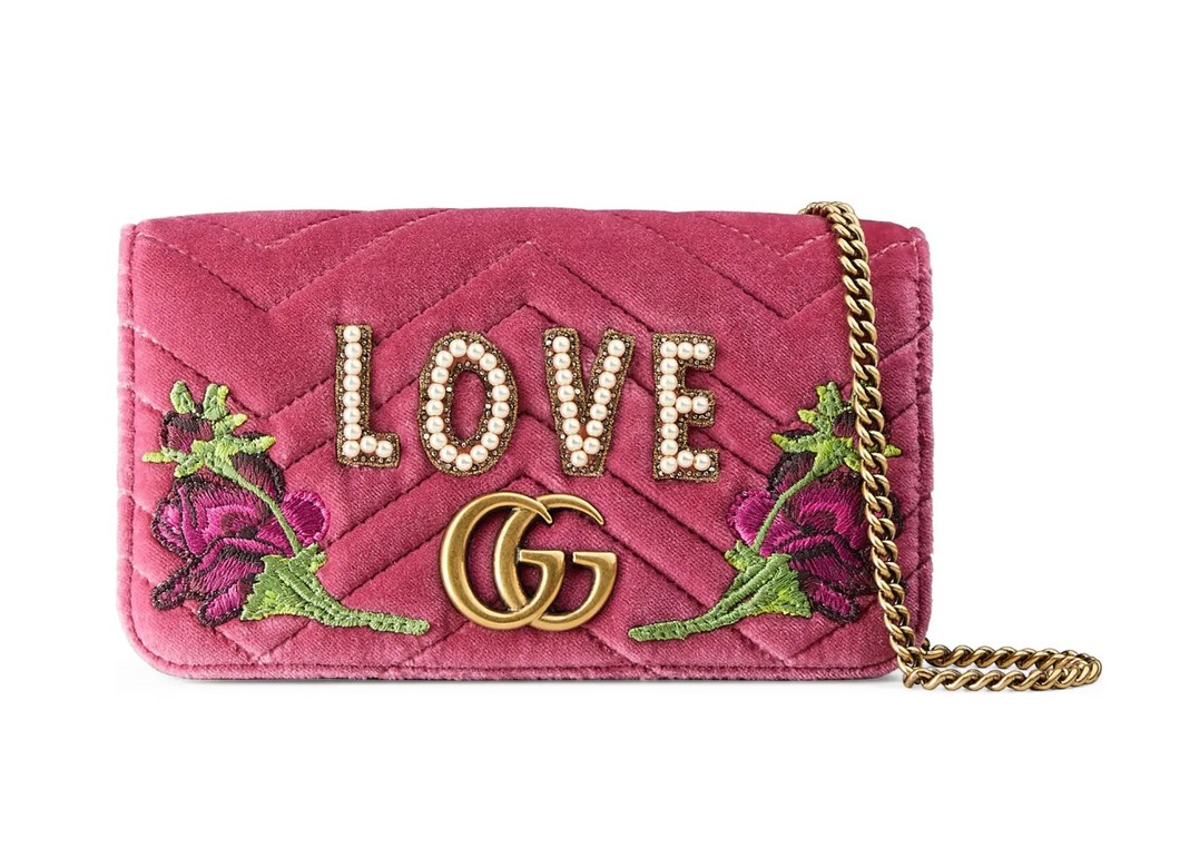 The Gucci Marmont Velvet Love Mini Shoulder Bag in Pink is velvety and gorgeous. Spelled out in imitation pearls and surrounded by sparkling beads, the word 