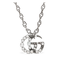 Load image into Gallery viewer, The Gucci GG Marmont Crystal Necklace In Silver is a rare and unique piece by none other than Gucci. A crystal encrusted GG pendant hangs from a delicate, intricately carved chain. A feline head charm hangs from the clasp. 