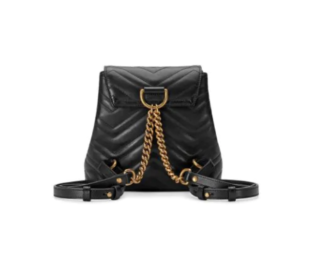 The Gucci Black Marmont Quilted Leather Backpack features adjustable shoulder straps with post-stud fastening. Logo plaque at face. Fold over flap with magnetic tab fastening. Drawstring fastening at throat. Patch pocket and leather logo flag at interior. Leather lining in beige. Antiqued gold-tone hardware. Tonal stitching.