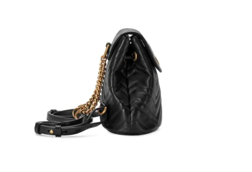 The Gucci Black Marmont Quilted Leather Backpack features adjustable shoulder straps with post-stud fastening. Logo plaque at face. Fold over flap with magnetic tab fastening. Drawstring fastening at throat. Patch pocket and leather logo flag at interior. Leather lining in beige. Antiqued gold-tone hardware. Tonal stitching.