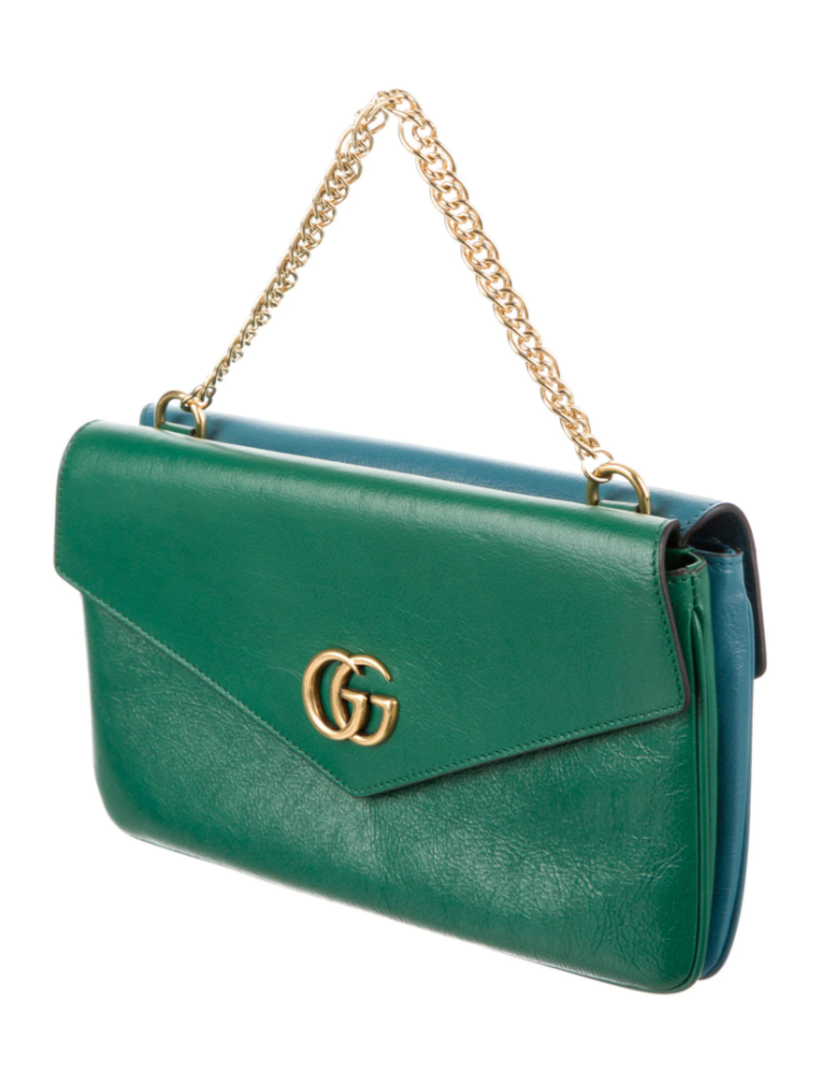 This is a two toned, double sided Gucci bag. The style is called Thiara and it looks like two envelopes back to back. One side is a mellow Robin blue. The other side is a jade green. The blue side has a jewel encrusted Raja tiger head on the magnetic clasp. The green side has the iconic double GG on the button clasp. There is a fixed Gucci gold short chain on the top and a strap is also included to make this a should bag or crossbody.