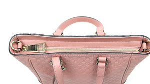 Pink crossbody tote bag Gold-tone hardware featuring Gucci charm 100% leather in GG Microguccissima pattern Linen interior lining Top zip closure Detachable and adjustable shoulder strap 2 slip pouches, 1 zipped pocket Leather tassel detail 8.5" x 11.5" x 4.5"  Strap Drop 19-21 Handle drop 3.5" Product number 449241 Made in Italy 