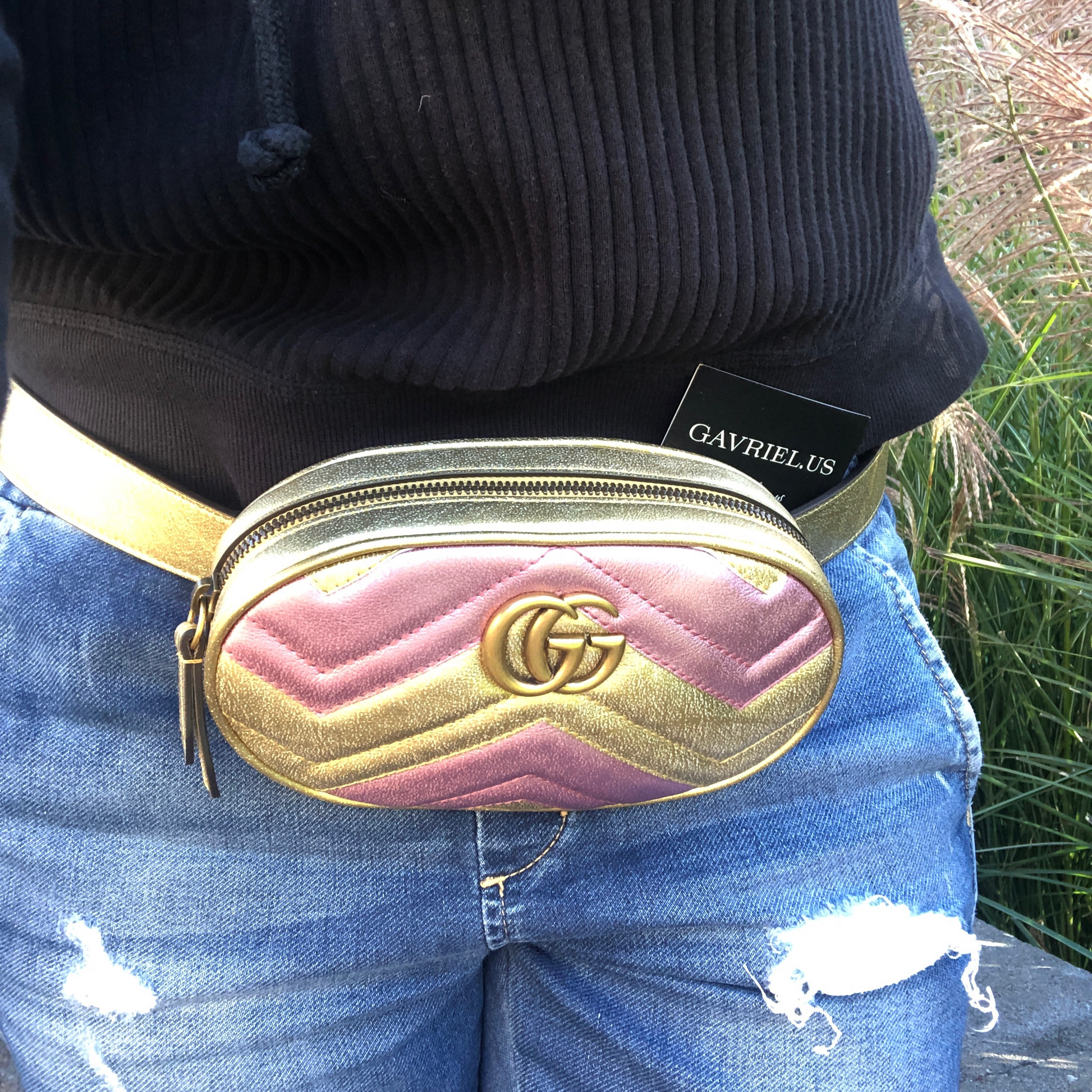 This belt bag is crafted of smooth gold and pink chevron stitched leather. This bag is an oval shape with a leather belt that can be worn as a belt bag. The belt bag features an aged gold GG logo on the front and a heart stitched shape on the back of the bag with an adjustable belt closure. The handbag opens to a blue satin interior with a patch pocket. This compact, yet spacious belt bag is perfect for any time of the day; whether it be for casual or formal wear, from Gucci!