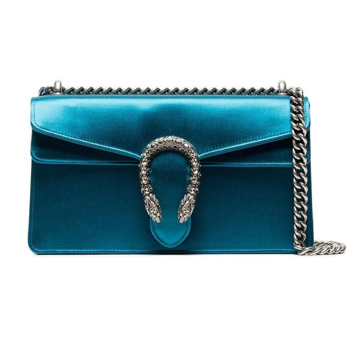 The Gucci Small Dionysus Satin Shoulder Bag in Blue is a structured bag, made of gleaming blue silk and contrast suede interior. The piece features a silver-tone chain shoulder strap, a fold-over top with snap closure, an internal slip pocket and a signature textured snake buckle embellishment. With delicate rhinestones for a touch of sparkle, this item also includes a swatch so you can match your look around this magnificent accessory. 