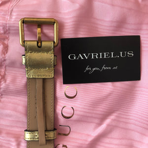 This belt bag is crafted of smooth gold and pink chevron stitched leather. This bag is an oval shape with a leather belt that can be worn as a belt bag. The belt bag features an aged gold GG logo on the front and a heart stitched shape on the back of the bag with an adjustable belt closure. The handbag opens to a blue satin interior with a patch pocket. This compact, yet spacious belt bag is perfect for any time of the day; whether it be for casual or formal wear, from Gucci!