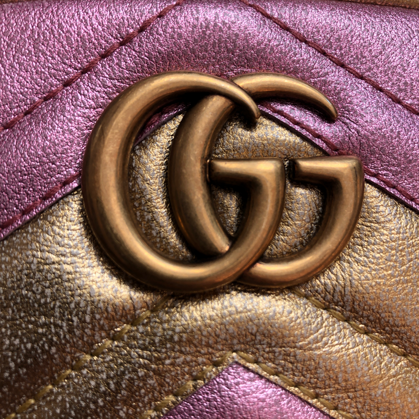 This belt bag is crafted of smooth gold and pink chevron stitched leather. This bag is an oval shape with a leather belt that can be worn as a belt bag. The belt bag features an aged gold GG logo on the front and a heart stitched shape on the back of the bag with an adjustable belt closure. The handbag opens to a blue satin interior with a patch pocket. This compact, yet spacious belt bag is perfect for any time of the day; whether it be for casual or formal wear, from Gucci!