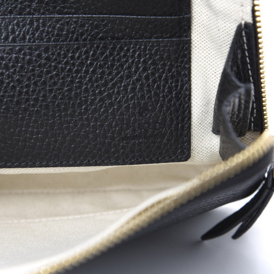 The Gucci Calfskin GG Marmont Pouch in Black is crafted of lovely textured calfskin leather in black. This bag features a top zipper that opens to a beige fabric interior with a zipper pocket and card slots on one side and a single pouch pocket on the opposite.