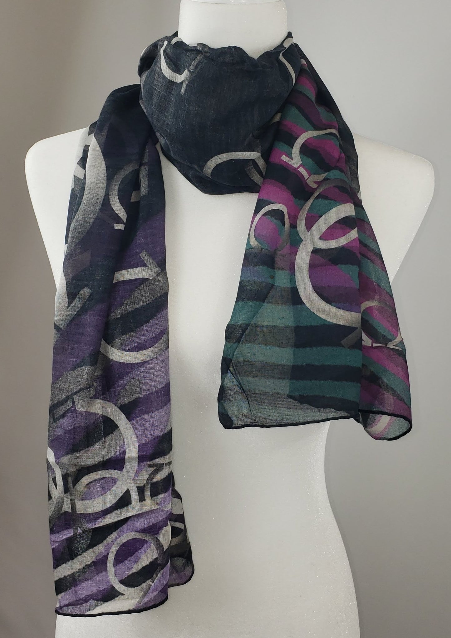 It has a gorgeous blend of blanks, tans, and purples woven into a tiger print, overlain with classic Ferragamo logos. This design has a simple mix of colors that adds a sense of refinement and beauty to your outfit. Whether it's paired with a sophisticated jacket or worn as an elegant shaw, this versatile accessory will make you look and feel your best!  Black and purple tiger print with classic Ferragamo logos 92% Modal, 8% Cachemire  60.25" x 16.5" (153cm x 42cm) Comes in Ferragamo Scarf Box Made in Italy