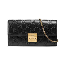 Load image into Gallery viewer, The Gucci Padlock Continental Wallet on a Chain in Black is the chic, everyday piece of luxury you desire. Black leather is embossed int eh signature interlocking GG pattern in a continental style wallet. The top flap is securely fastened with a padlock clasp in a polished gold-tone. A small removable strap allows this piece to effortlessly transition between wallet, clutch, and handbag. The interior includes  5 bill slots, 12 credit card slots, and 1 zippered compartment to keep you organized all day long.