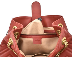 The Gucci GG Marmont Apollo Chevron Tote Shoulder Bag in Red is a unique piece that features the chevron, zig zag patterned stitching in a smooth calfskin red leather. The curved silhouette hangs from two chain shoulder straps with leather pads, while a GG logo in gold-tone hardware sits on the front and a stitched GG is on the back. 